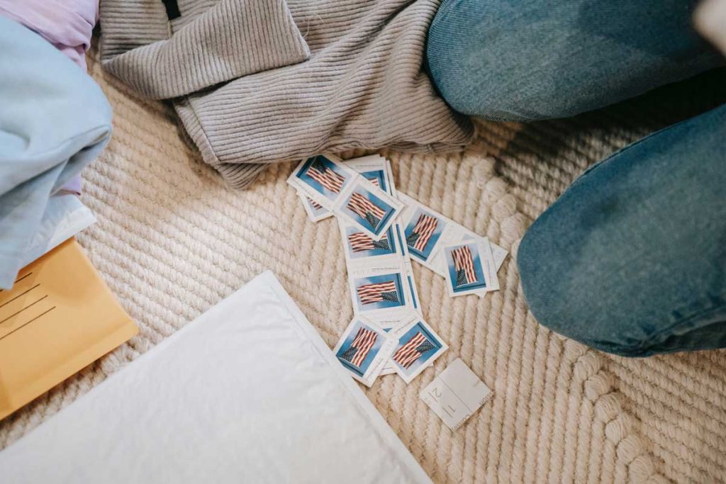 Slippers and a sweater lie on the carpet next to lots of US Post stamps