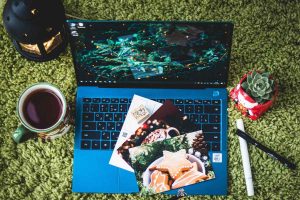 A blue laptop with postcards resting on top representing the different types of penpal