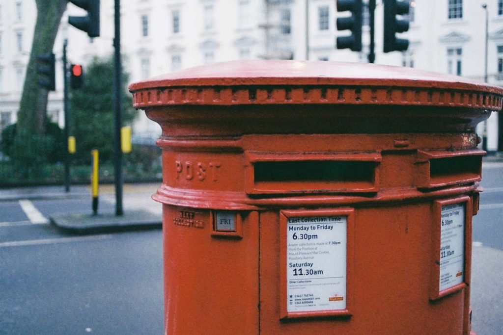 British postbox with postcard delivery times on it