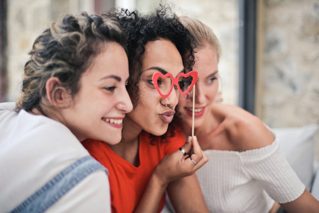 3 women posing with comedy glasses for a selfie having uses apps to find each other as friends