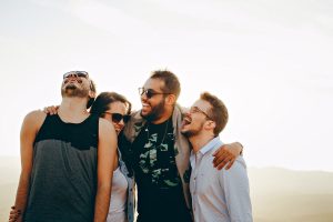 A group of 4 friends hug each other laughing