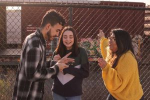 A group of three friends using apps to find friends on a phone