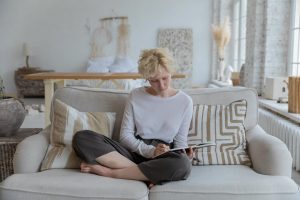 A woman writing on her boho chic sofa