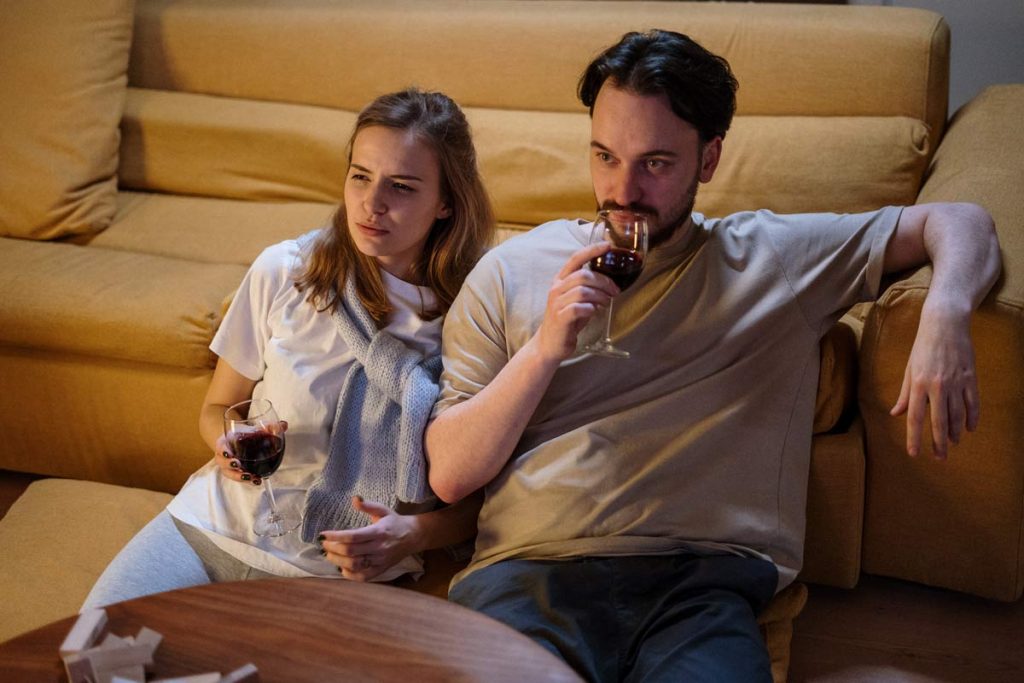 A couple sit watching the TV