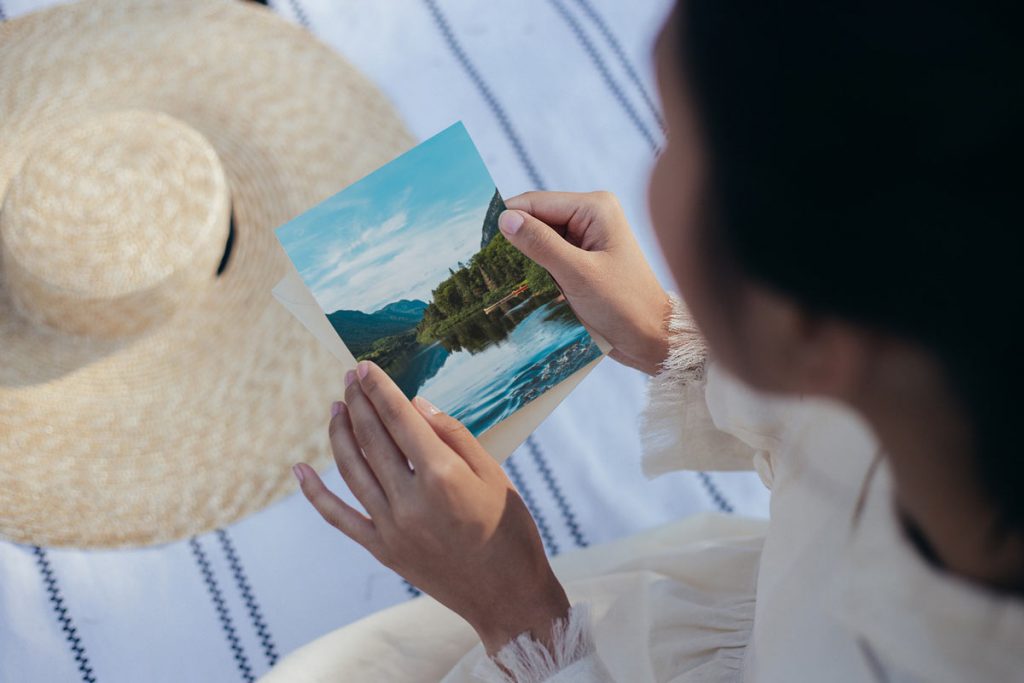 A postcard featuring a lake held in the hands