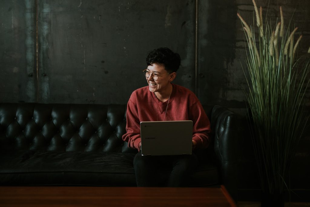 Girl sitting in front of her laptop and laughing